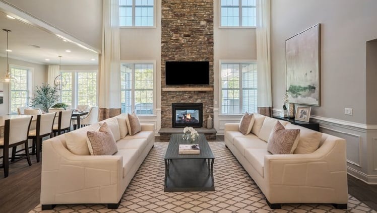 Stacked stone fireplace with 2 cream sofas.