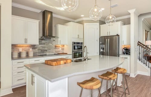 Curved island takes center stage in the gray and white kitchen.