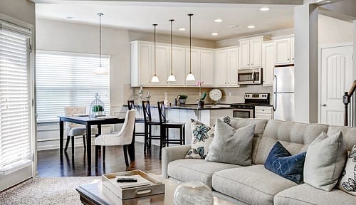 Open floor plan with white kitchen cabinets creating a bright airy feel.