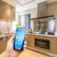 Person holding smart phone in kitchen.
