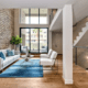 Living room with exposed brick wall with large windows.