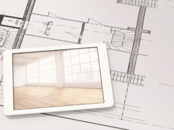 Smart device laying on top of blue prints.