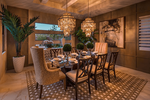 Dining room in neutral tones with an opulent chandeliers.