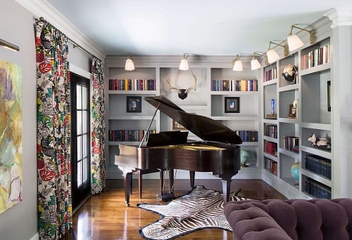 Grand piano in front of bookshelf.