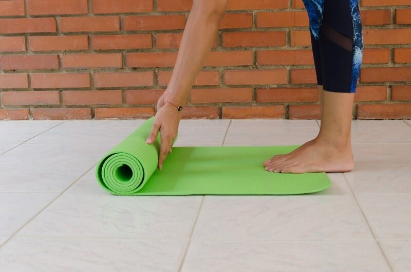 Woman standing on yoga mat.