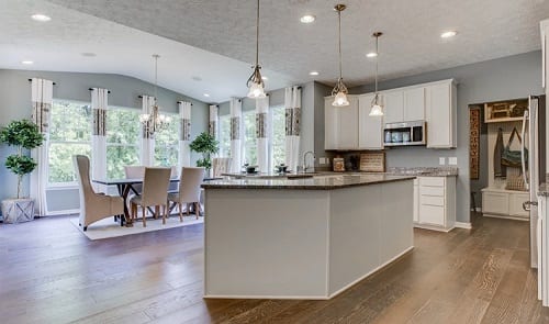 Kitchen with island and 3 pendant lights hanging.