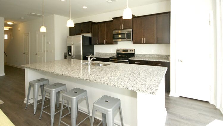 Kitchen with granite countertops and large island with seating.