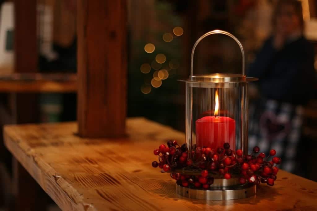 Lit candle surrounded by cranberries.