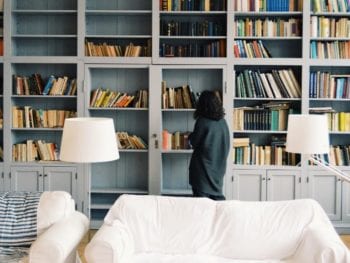 Person standing in front of a bookshelf.